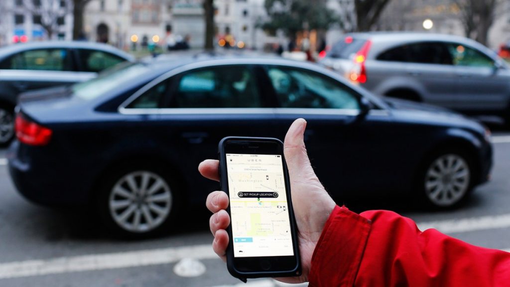 person with map on smartphone in front of a road