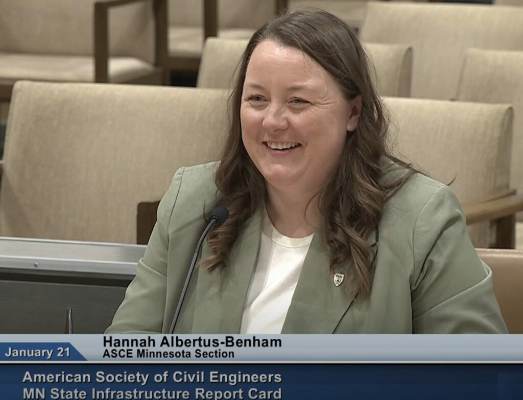 Woman speaking as witness to elected officials in hearing room